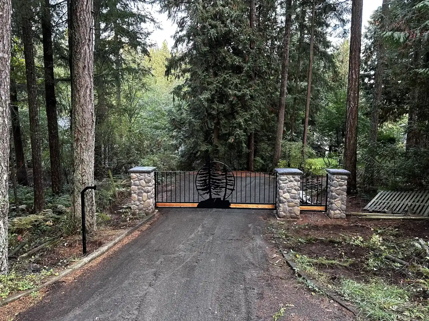 Driveway gate between stone pillars