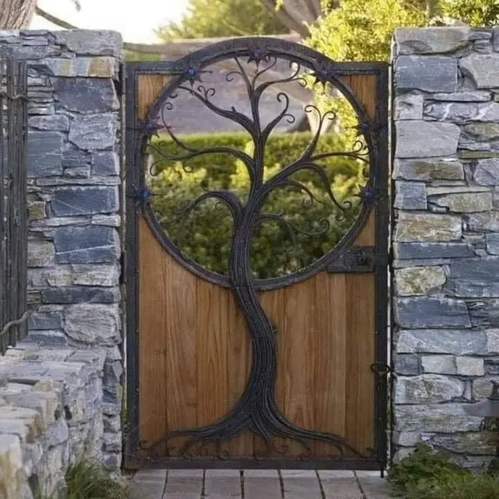Tree of life garden gate set in a stone wall