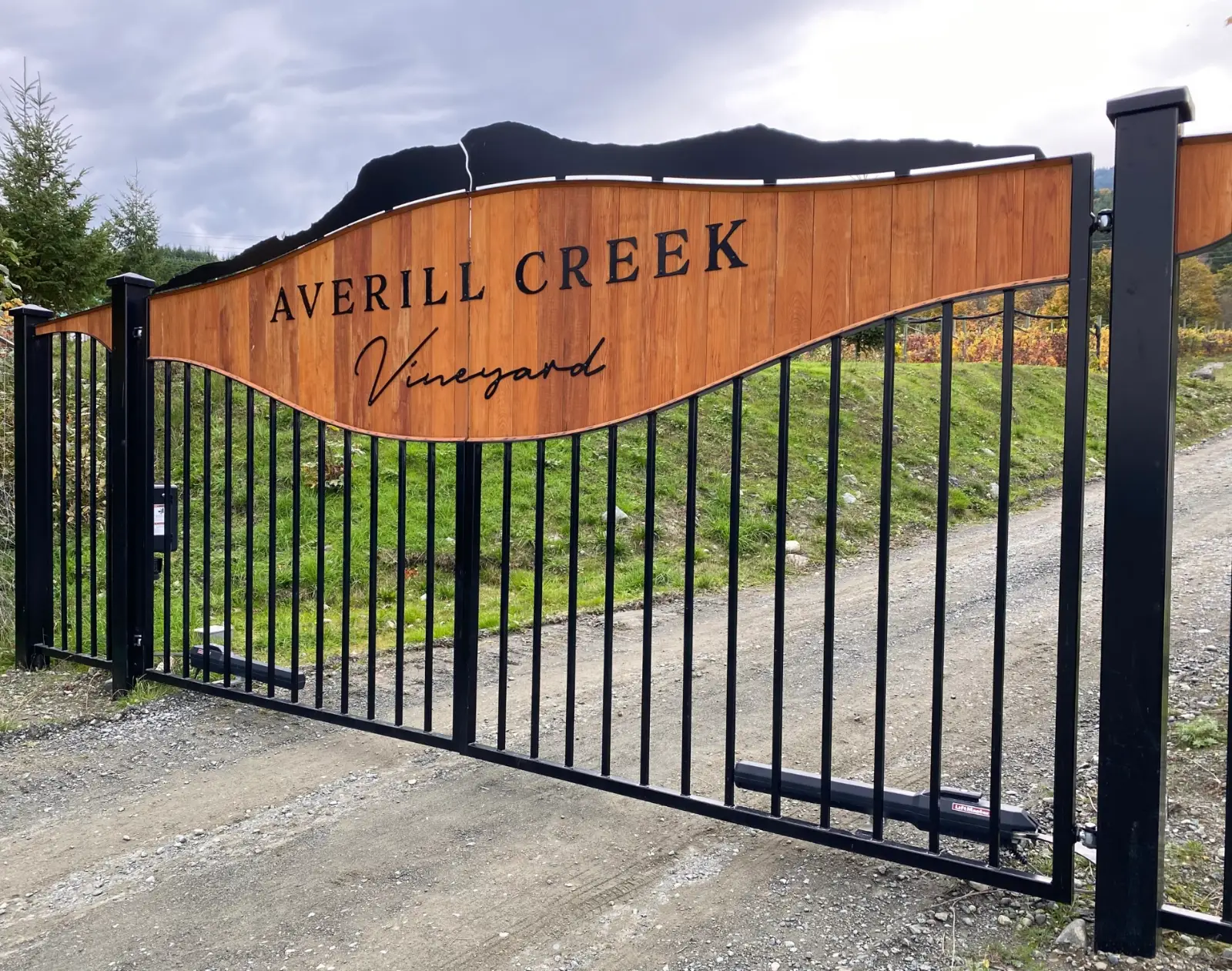 Averill Creek Vineyard entrance gate with a curved cedar sign panel